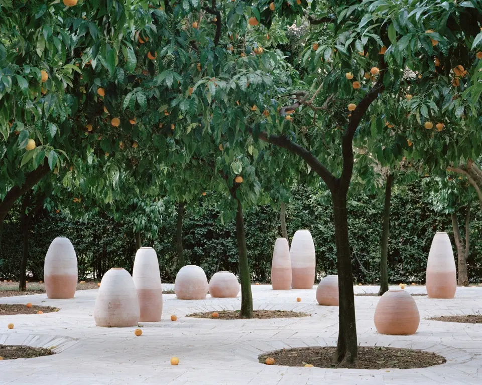 Aquifère’s terracotta vessels and stone platform in Villa Medici’s orange garden