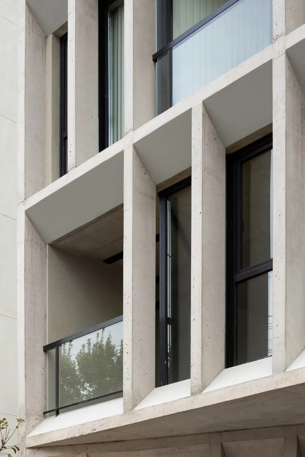 Deep concrete facade framing a balcony, photograph by Ramiro Sosa