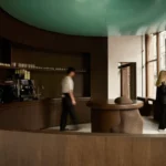 Circular coffee counter beneath a turquoise ceiling installation at Elan