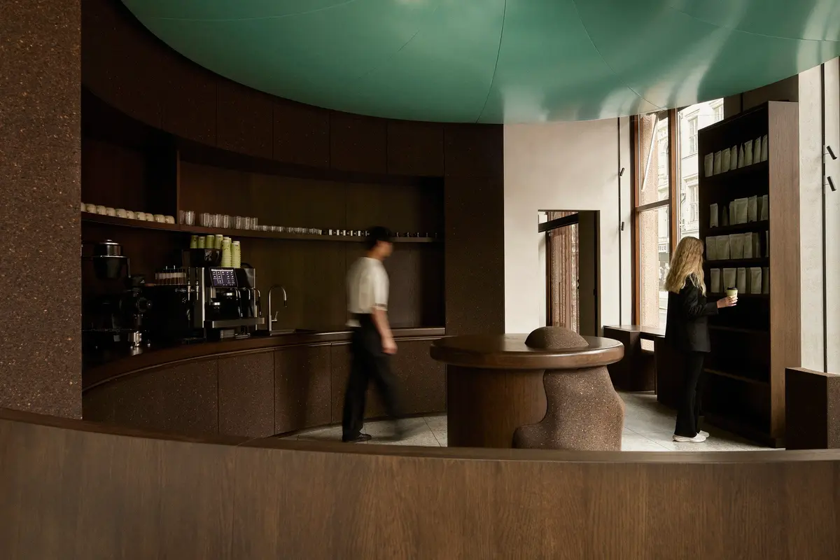 Circular coffee counter beneath a turquoise ceiling installation at Elan