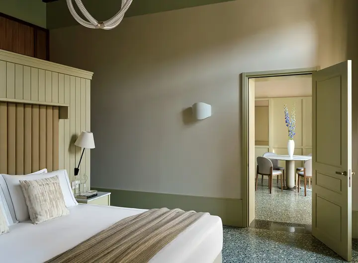 Lagoon-green guest room opening into a living area