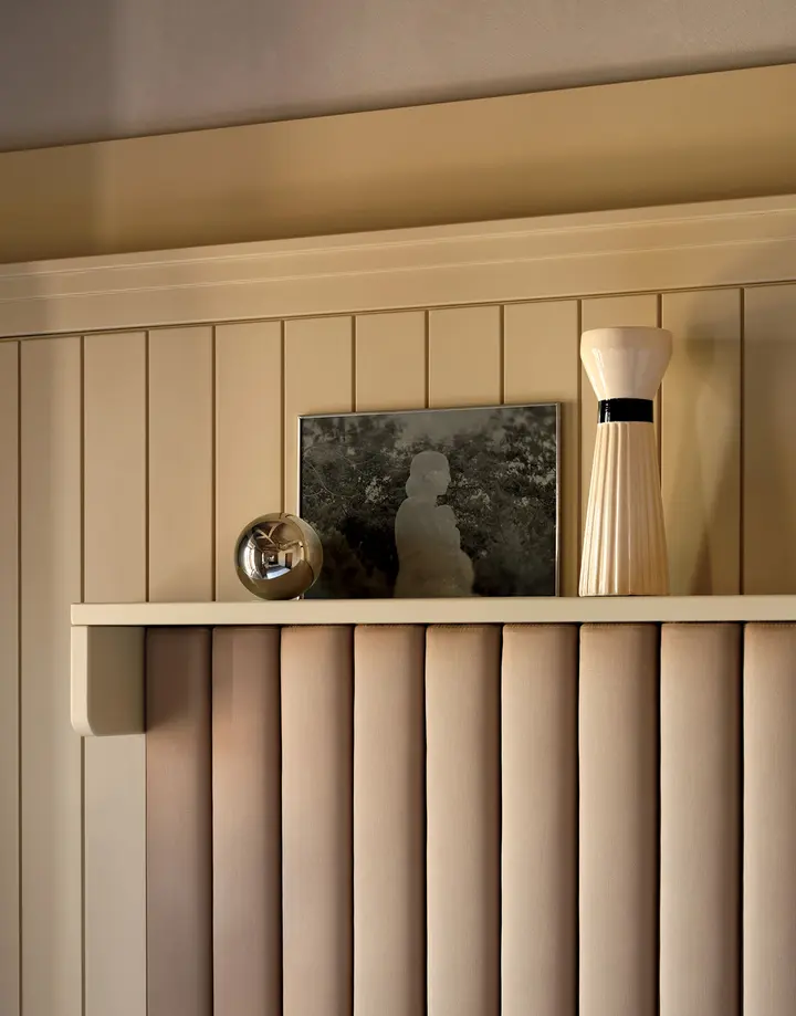 Upholstered headboard and timber panel detail in a guest room