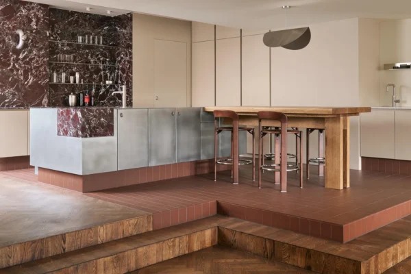Kitchen with stainless-steel island, oak dining table and burgundy marble at Home Herengracht, photographed by Maarten Willemstein