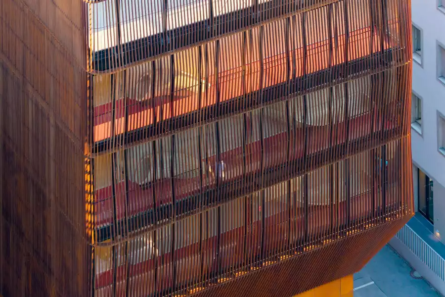 Slides and play spaces behind the Corten steel screen of Kinderoase