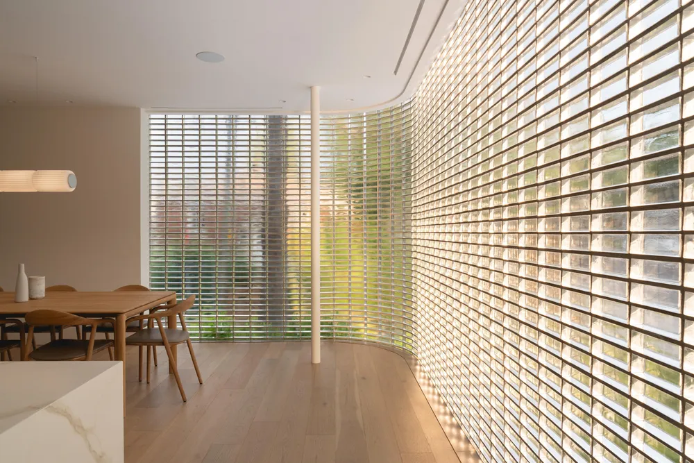 Dining area beside translucent glass-block wall, photograph by Raphaël Thibodeau