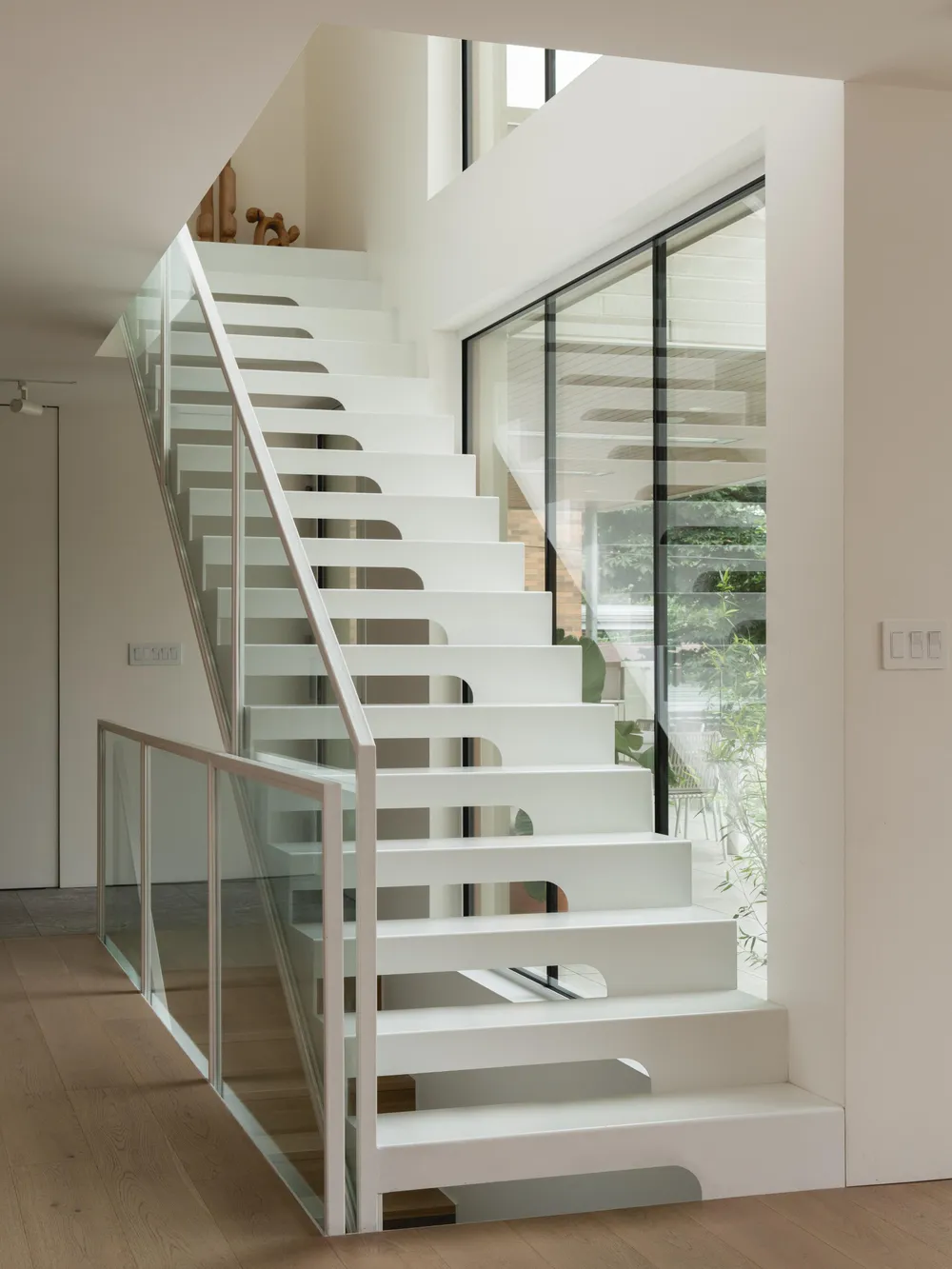 White steel staircase connecting the house levels, photograph by Raphaël Thibodeau