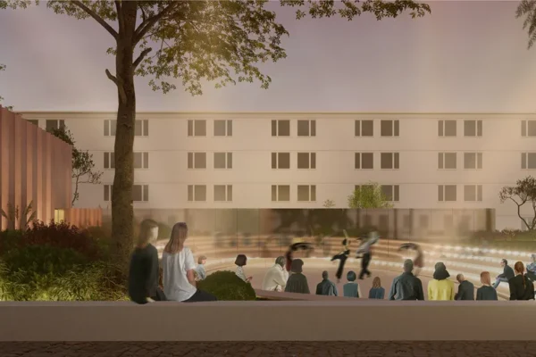 Evening visualization of Trace's sunken amphitheatre, with stepped seating, trees, and cultural pavilion in Peja
