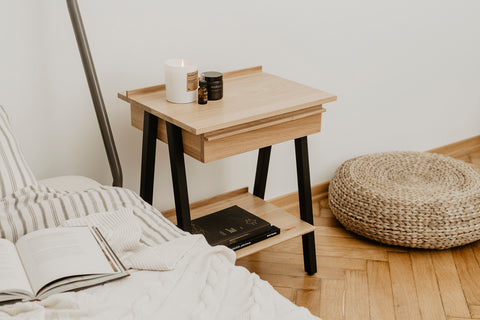 Troost oak bedside table by Agata Nowak for Borcas, beside a bed.